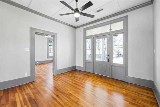 foyer featuring ornamental molding, baseboards, visible vents, and hardwood / wood-style floors