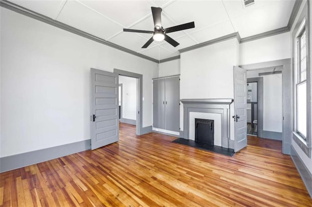 unfurnished living room with ornamental molding, a fireplace, light wood-style flooring, and a ceiling fan