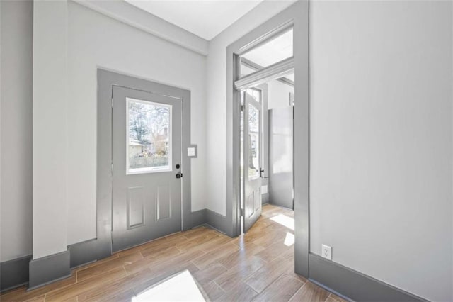 entryway with baseboards and wood finish floors