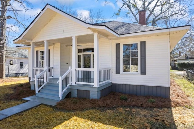 view of front of home featuring a porch, a shingled roof, a chimney, and ceiling fan