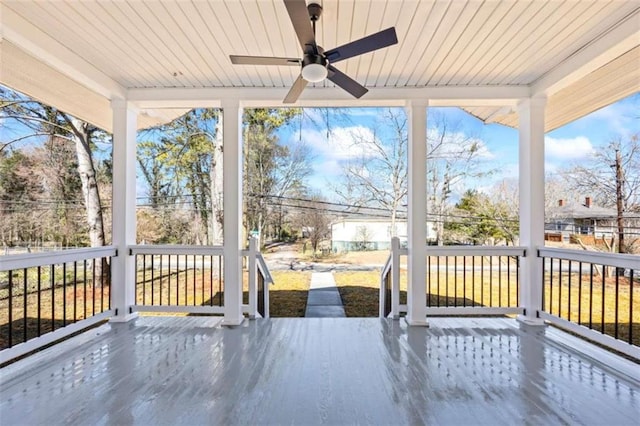 unfurnished sunroom with ceiling fan, plenty of natural light, and wood ceiling