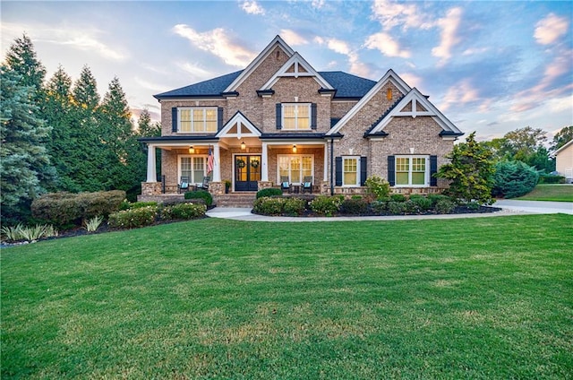 craftsman-style home with covered porch and a yard