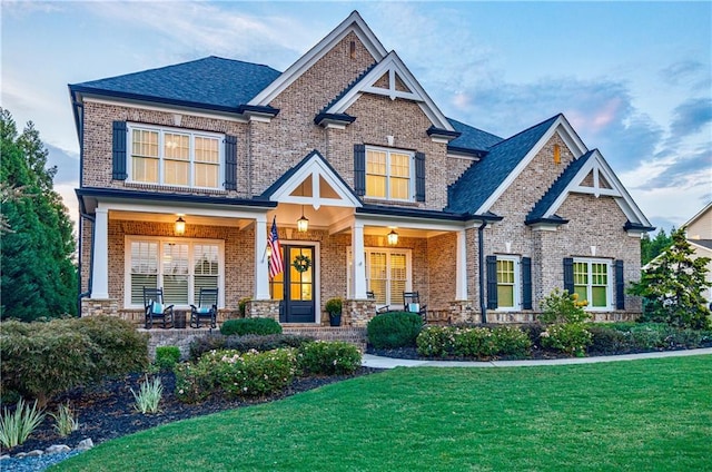 craftsman house with covered porch and a front lawn