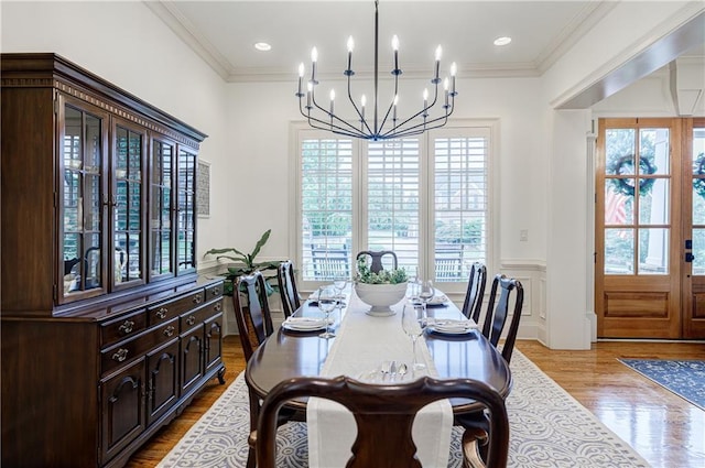 dining area featuring a notable chandelier, light wood-type flooring, and crown molding