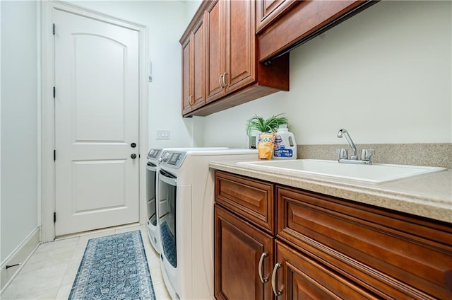 clothes washing area with cabinets, light tile patterned floors, sink, and washing machine and clothes dryer