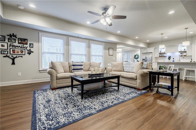 living room featuring ceiling fan and dark wood-type flooring