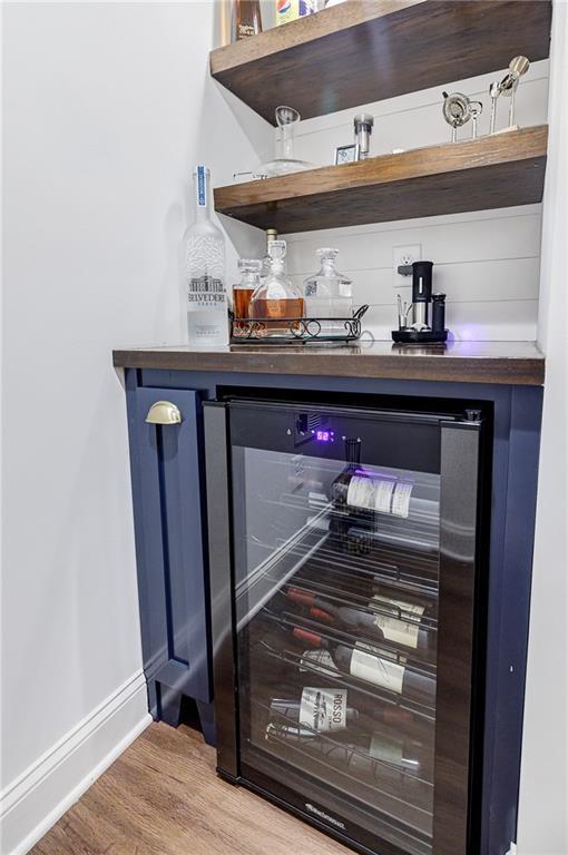 bar featuring hardwood / wood-style floors and beverage cooler