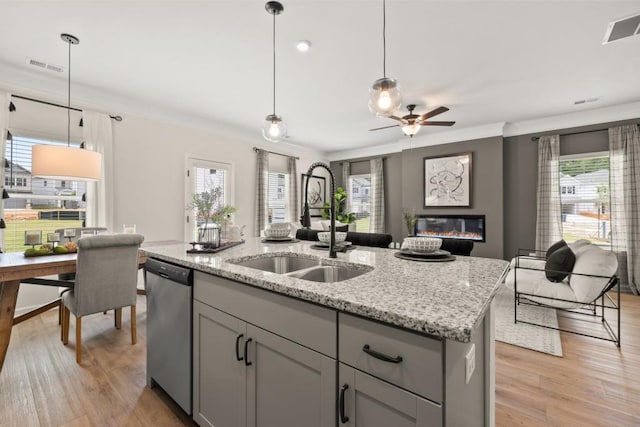 kitchen with decorative light fixtures, a center island with sink, gray cabinetry, ceiling fan, and sink