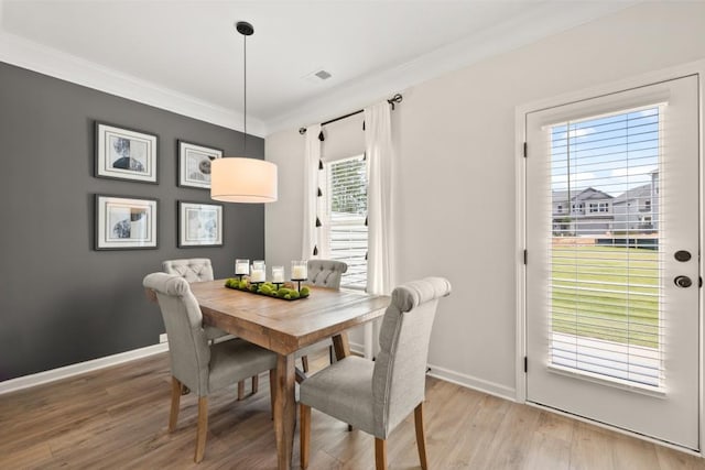 dining area featuring ornamental molding and light wood-type flooring