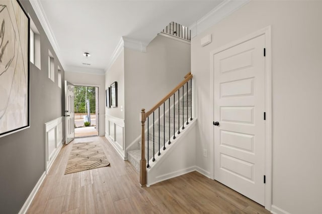 entrance foyer featuring light hardwood / wood-style flooring and crown molding