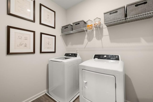 clothes washing area with separate washer and dryer and dark wood-type flooring