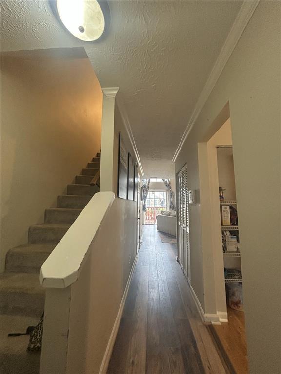 3414 Bayshore Dr, Atlanta, GA 30340 - hall with crown molding, wood finished floors, a textured ceiling, stairs, and baseboards