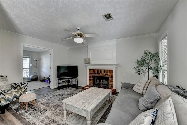 5385 Spotted Fawn Ct, Suwanee, GA 30024 - living room with a ceiling fan, wood finished floors, a brick fireplace, crown molding, and a textured ceiling