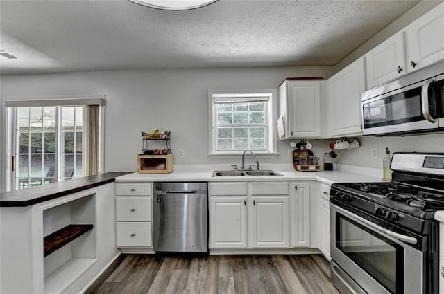 5385 Spotted Fawn Ct, Suwanee, GA 30024 - kitchen with stainless steel appliances, a peninsula, white cabinetry, a textured ceiling, and open shelves