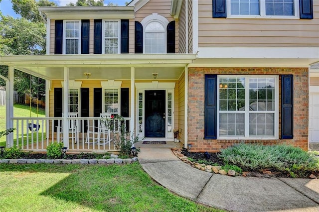 5385 Spotted Fawn Ct, Suwanee, GA 30024 - entrance to property with covered porch, brick siding, and a yard