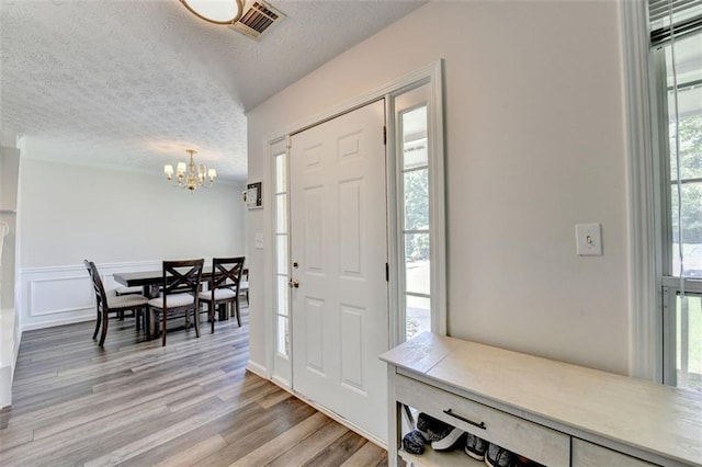 5385 Spotted Fawn Ct, Suwanee, GA 30024 - entryway with a chandelier, light wood-style flooring, and a textured ceiling