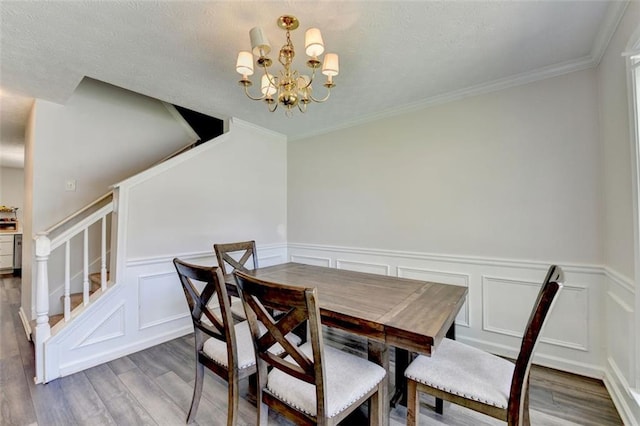 5385 Spotted Fawn Ct, Suwanee, GA 30024 - dining area featuring stairs, wood finished floors, a chandelier, a textured ceiling, and a decorative wall