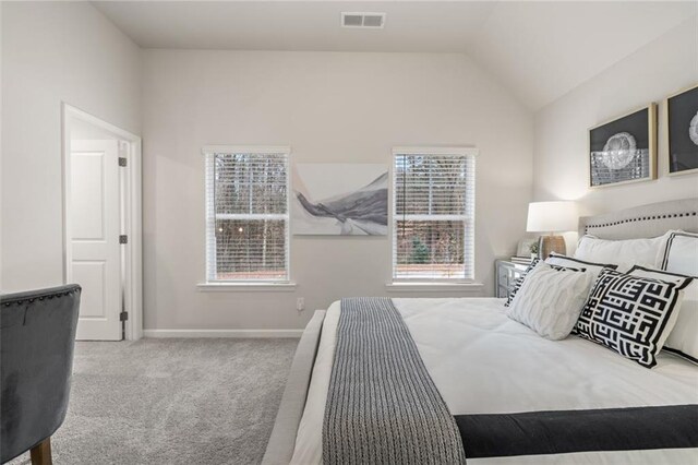 bedroom featuring vaulted ceiling and light carpet