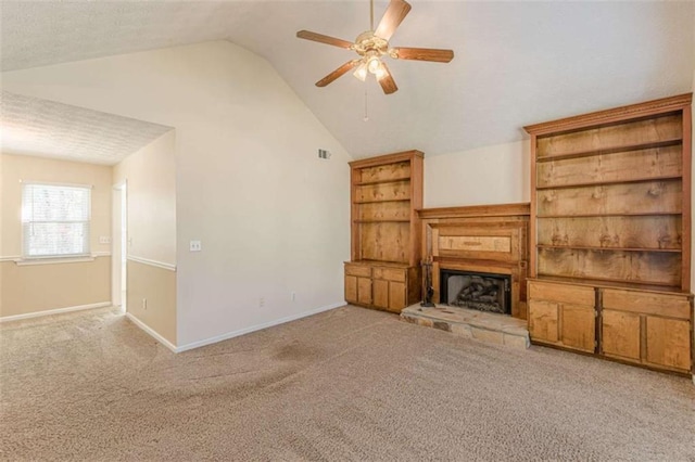 unfurnished living room featuring visible vents, carpet floors, lofted ceiling, and a fireplace with raised hearth