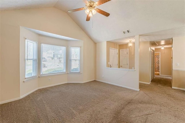 unfurnished room featuring lofted ceiling, carpet floors, attic access, and ceiling fan