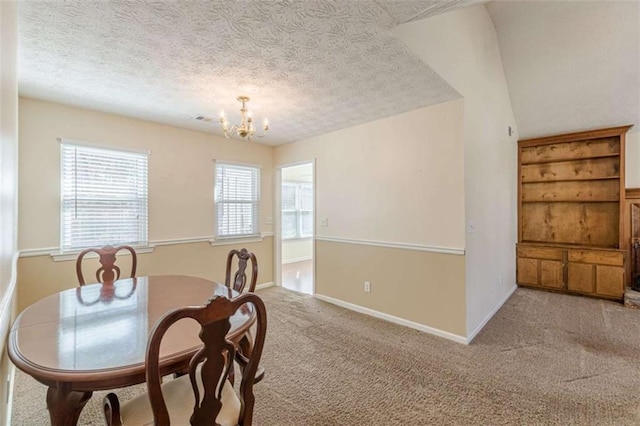 carpeted dining space featuring visible vents, baseboards, a textured ceiling, and an inviting chandelier