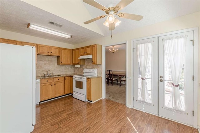 kitchen with white appliances, visible vents, a sink, french doors, and under cabinet range hood