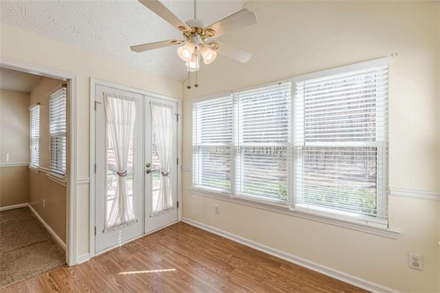 entryway with a textured ceiling, wood finished floors, french doors, baseboards, and ceiling fan