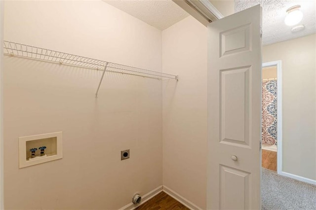 laundry area featuring laundry area, hookup for a washing machine, hookup for an electric dryer, and a textured ceiling