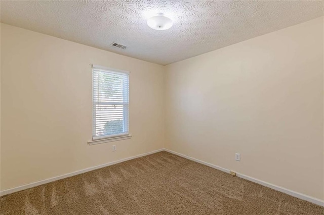 carpeted empty room with visible vents, a textured ceiling, and baseboards