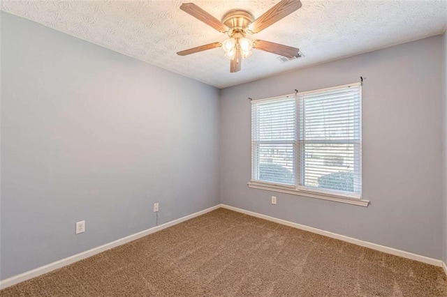 carpeted spare room with ceiling fan, baseboards, visible vents, and a textured ceiling