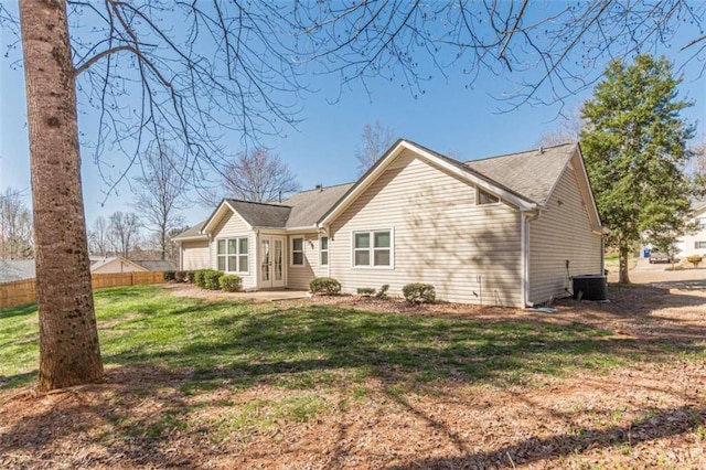 back of property with central air condition unit, french doors, a yard, and fence