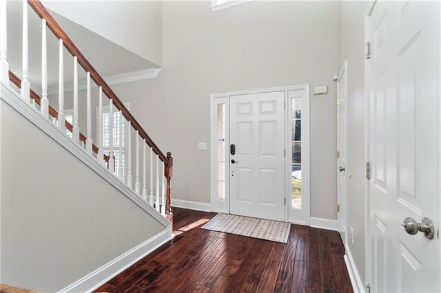 entryway with hardwood / wood-style floors and a high ceiling