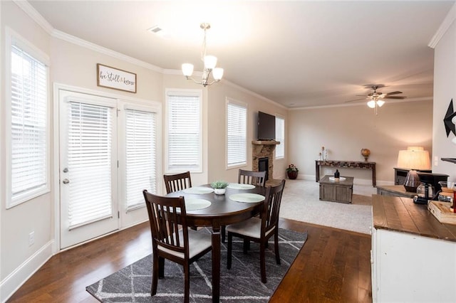 637 Little Bear Loop, Canton, GA 30114 - dining space featuring crown molding, dark wood-type flooring, a chandelier, a ceiling fan, and a fireplace
