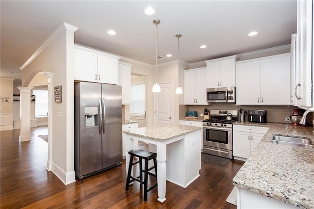 637 Little Bear Loop, Canton, GA 30114 - kitchen featuring appliances with stainless steel finishes, a sink, decorative columns, ornamental molding, and a kitchen island