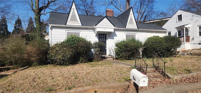 view of front of property with roof with shingles and a chimney