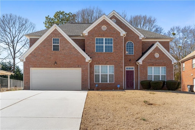 traditional home with concrete driveway, brick siding, and an attached garage