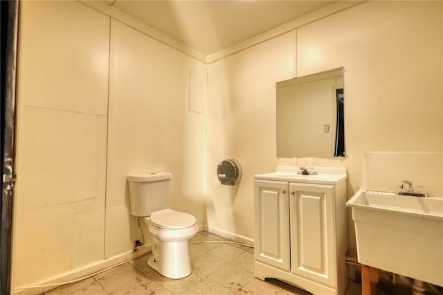 bathroom with toilet, tile floors, and vanity