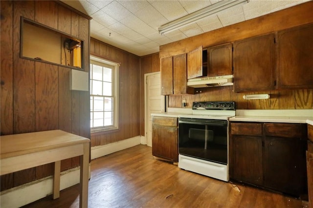 kitchen featuring dark wood-type flooring, electric stove, and wooden walls