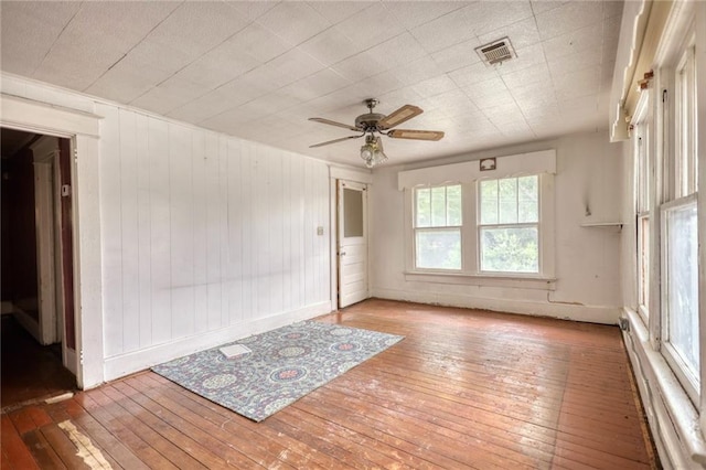 unfurnished room with ceiling fan, a baseboard radiator, and light wood-type flooring