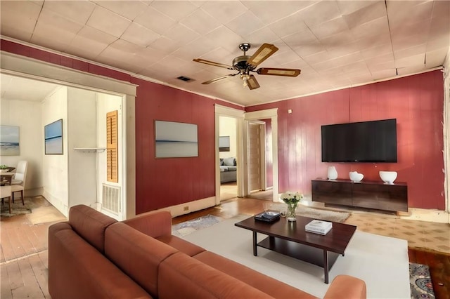 living room featuring light hardwood / wood-style floors, crown molding, and ceiling fan