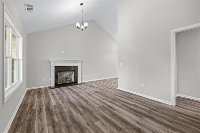 unfurnished living room with lofted ceiling, wood-type flooring, and a notable chandelier