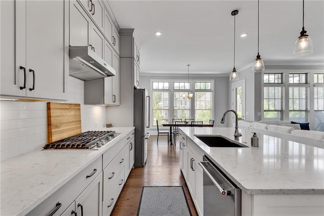 3108 Huntington Pl, Milton, GA 30004 - kitchen with under cabinet range hood, appliances with stainless steel finishes, a sink, a kitchen island with sink, and light stone counters