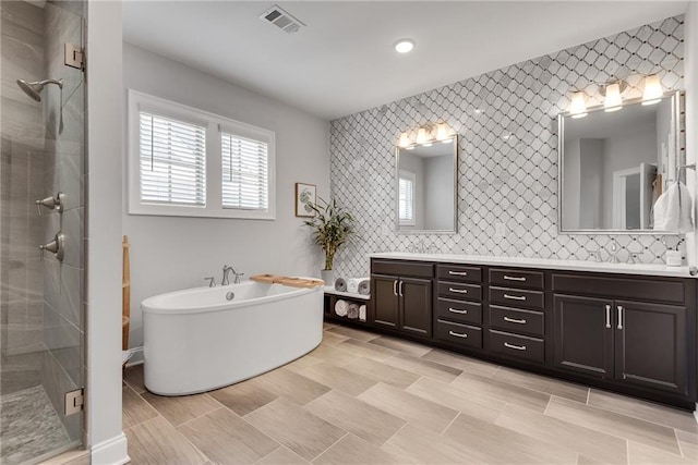 3108 Huntington Pl, Milton, GA 30004 - bathroom with double vanity, a shower stall, a freestanding tub, and recessed lighting