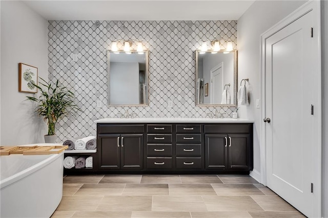 3108 Huntington Pl, Milton, GA 30004 - full bathroom featuring double vanity, a soaking tub, an accent wall, and decorative backsplash