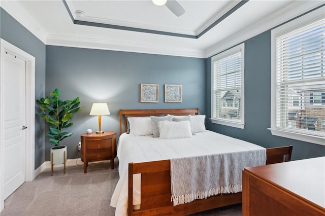 carpeted bedroom featuring a raised ceiling, a ceiling fan, and crown molding