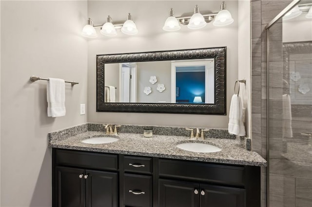 full bathroom with double vanity, a stall shower, and a sink