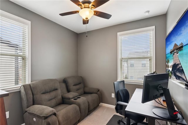 home office with a ceiling fan, a wealth of natural light, light carpet, and baseboards