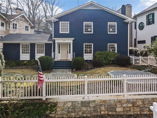 view of front of home featuring a fenced front yard and a chimney