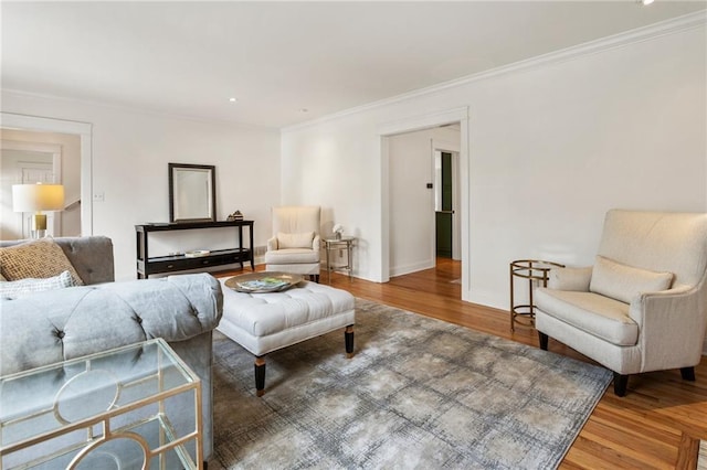 living room featuring crown molding, baseboards, and wood finished floors