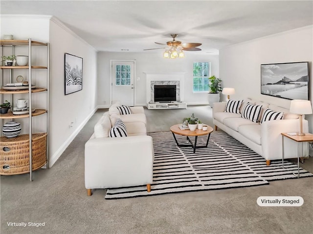 living area with a premium fireplace, baseboards, a ceiling fan, and crown molding